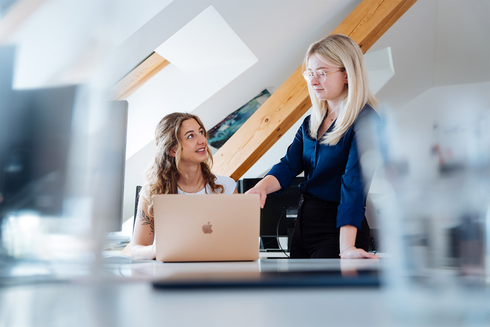 Zwei Frauen im modernen Büro sprechen über die Google Ads Agentur.