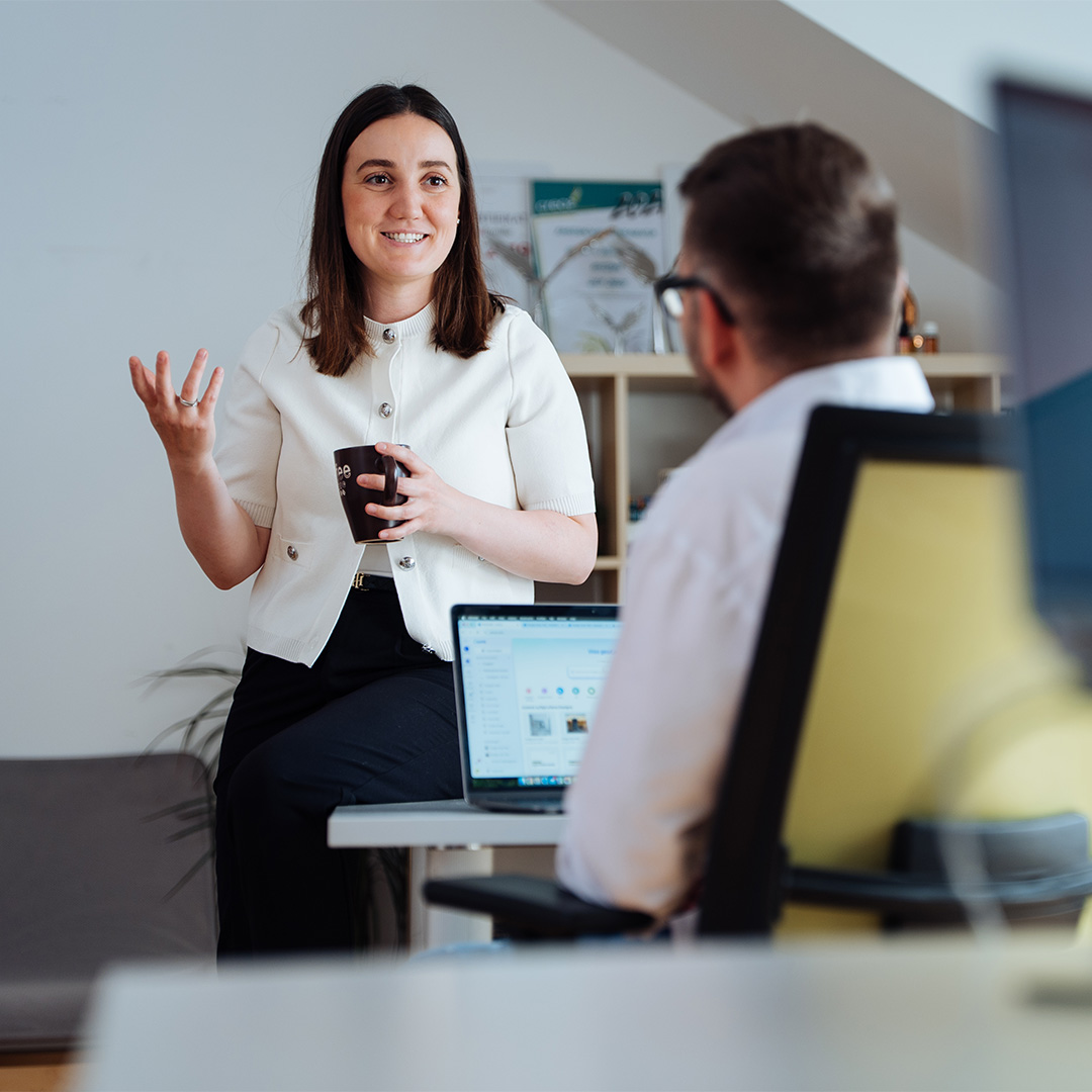 Frau spricht mit Kollegen in der Werbeagentur Kärnten